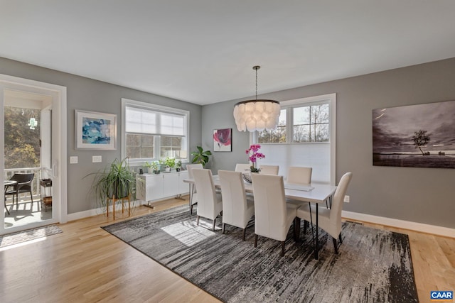 dining space featuring light wood-style floors, baseboards, and a healthy amount of sunlight