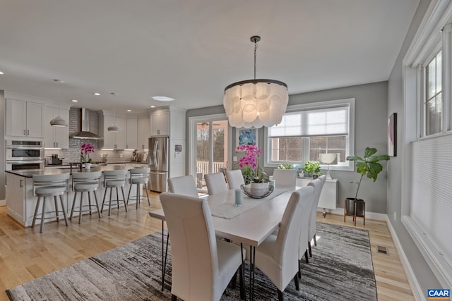 dining area featuring recessed lighting, visible vents, baseboards, and light wood-style flooring