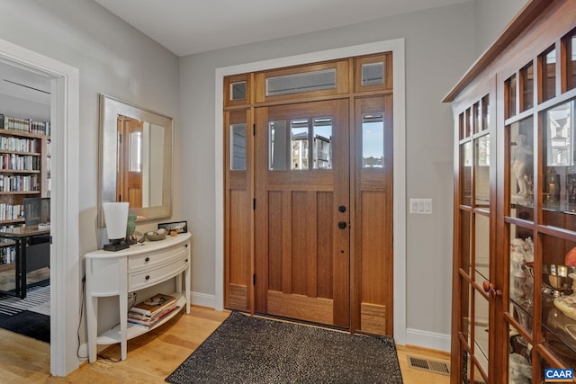 entryway featuring baseboards, visible vents, and light wood finished floors