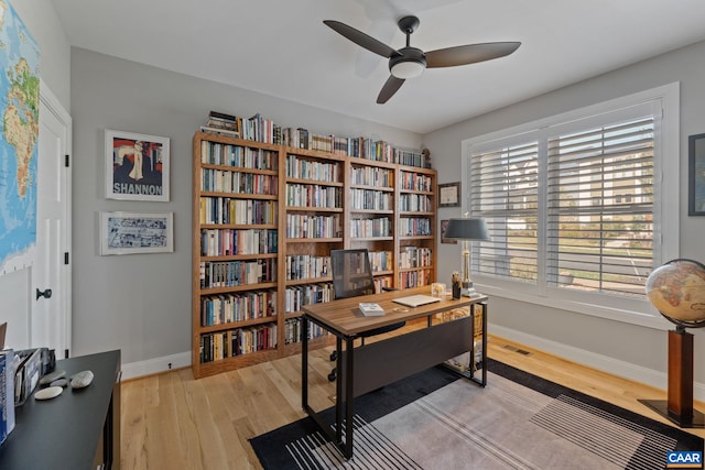 office area featuring visible vents, baseboards, light wood-style floors, and a ceiling fan