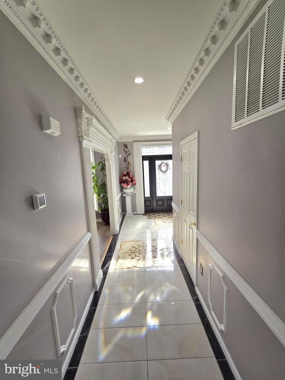 corridor featuring recessed lighting, tile patterned floors, visible vents, and crown molding