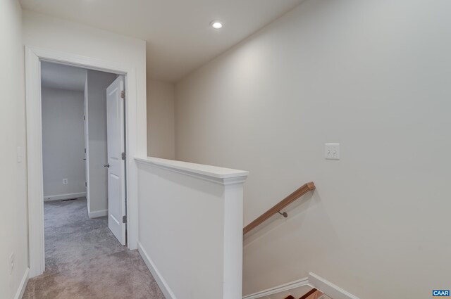 hall featuring light colored carpet