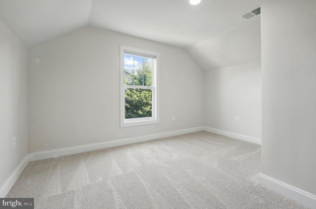 additional living space featuring visible vents, baseboards, carpet, and lofted ceiling