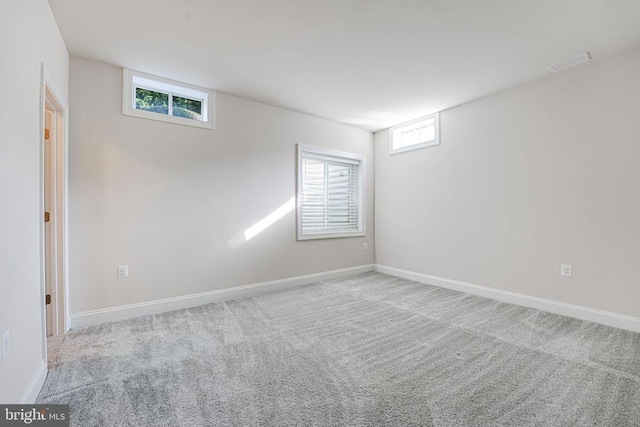 carpeted spare room featuring baseboards and visible vents
