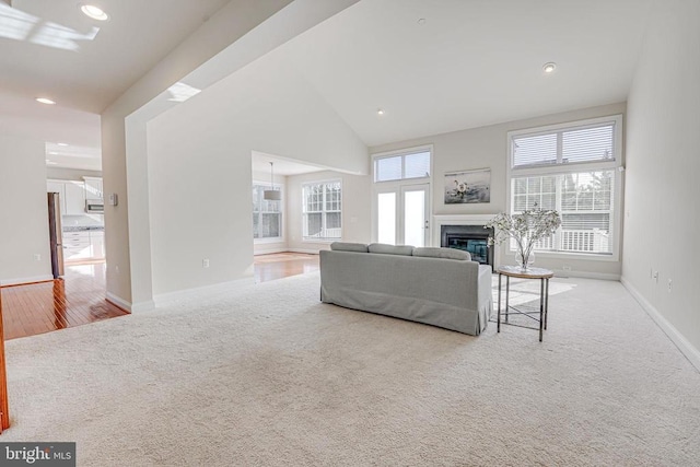carpeted living area with baseboards, recessed lighting, and a premium fireplace