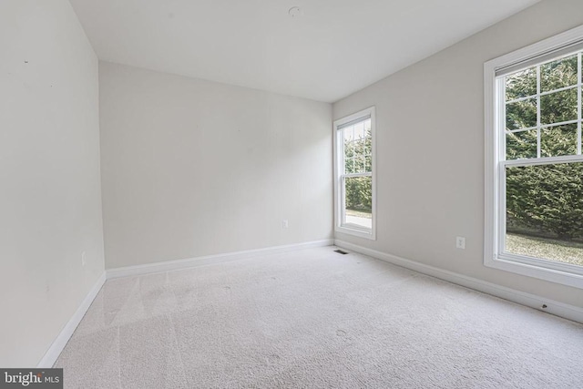 carpeted empty room featuring baseboards
