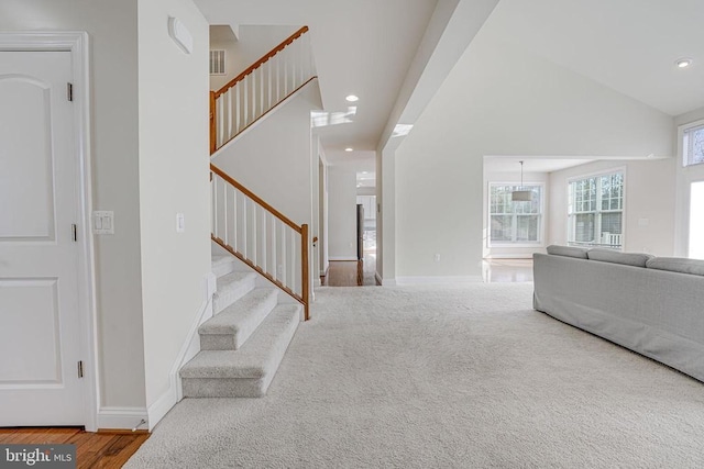 living area with recessed lighting, baseboards, wood finished floors, and stairway