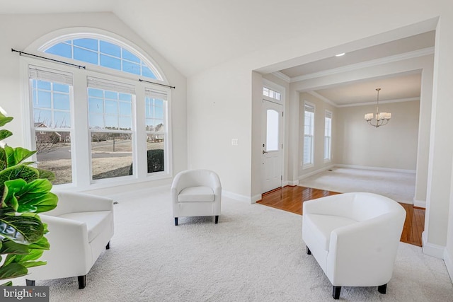 living room with a notable chandelier, baseboards, lofted ceiling, ornamental molding, and carpet