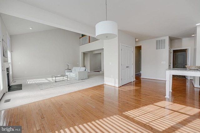 unfurnished living room featuring baseboards, a fireplace, wood finished floors, and visible vents