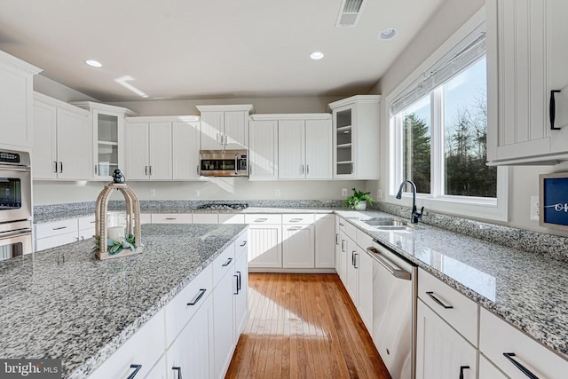 kitchen featuring a sink, stainless steel appliances, white cabinetry, recessed lighting, and visible vents