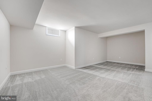 below grade area featuring baseboards and carpet