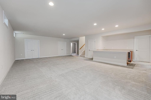 basement with recessed lighting, baseboards, light carpet, and stairway