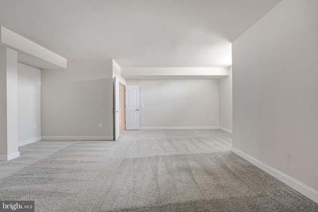 interior space featuring baseboards and light carpet