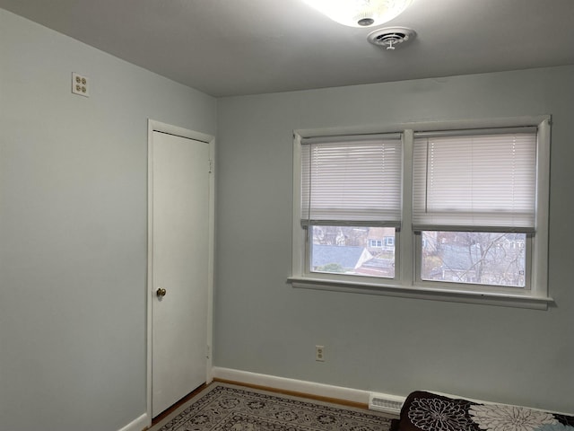 unfurnished bedroom featuring visible vents, baseboards, and wood finished floors