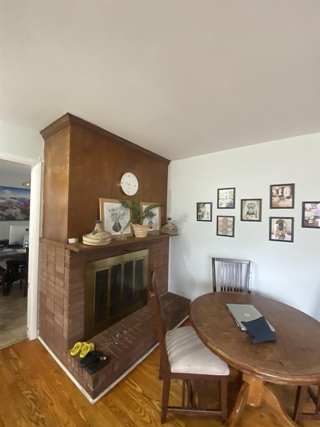 dining space with a fireplace and wood finished floors