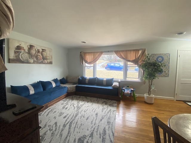 living area with baseboards and wood finished floors