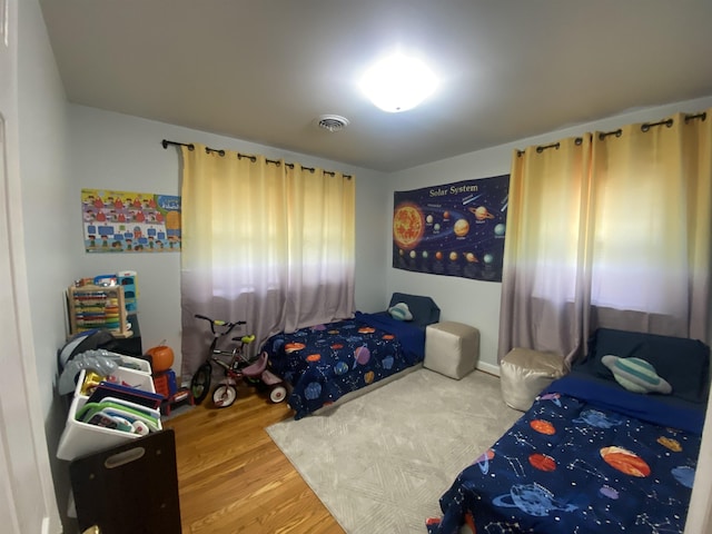 bedroom featuring visible vents and wood finished floors