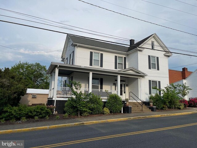 view of front of property featuring cooling unit and a porch