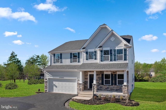 craftsman inspired home with driveway, stone siding, covered porch, a front yard, and a garage