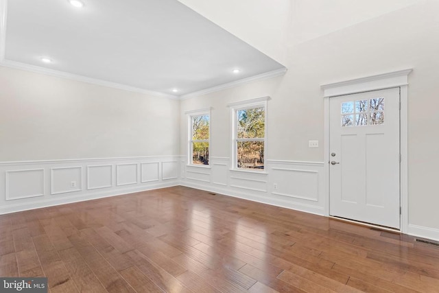 entryway with visible vents, wood finished floors, recessed lighting, wainscoting, and crown molding