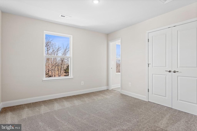 unfurnished bedroom featuring a closet, visible vents, baseboards, and carpet floors