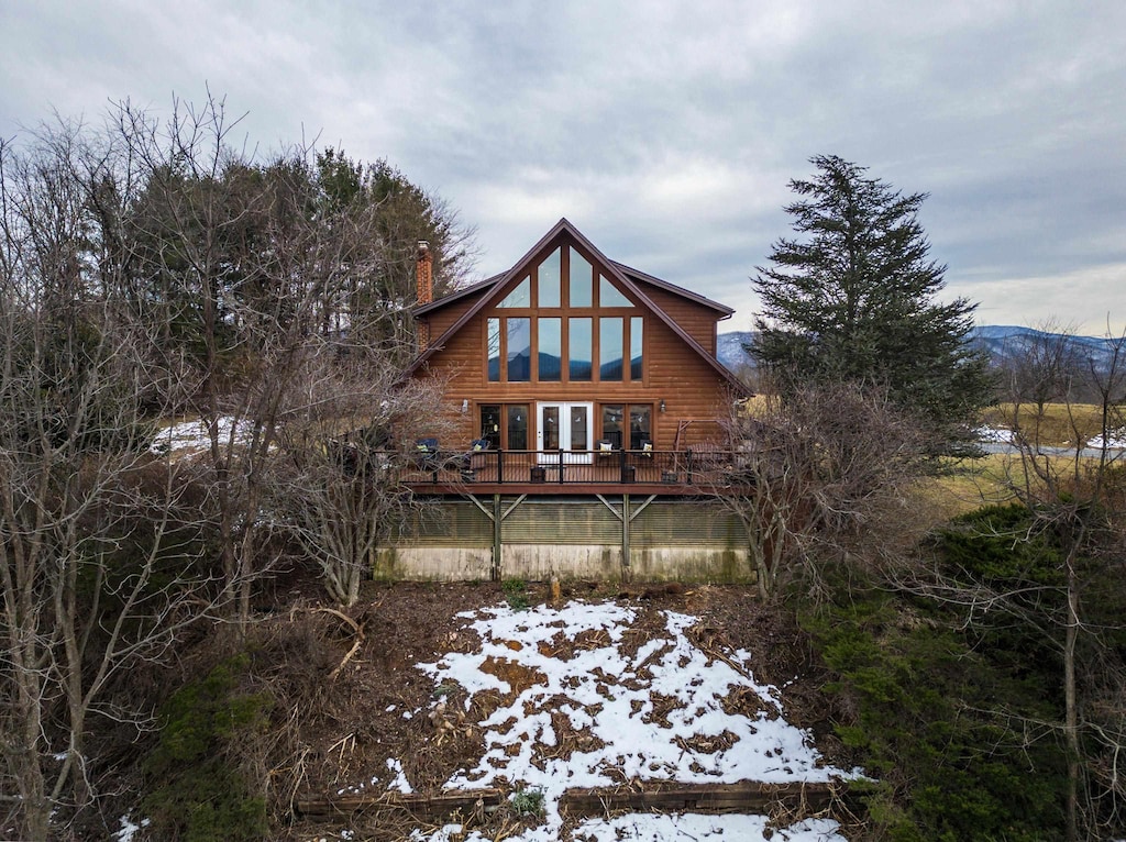 snow covered house featuring a wooden deck