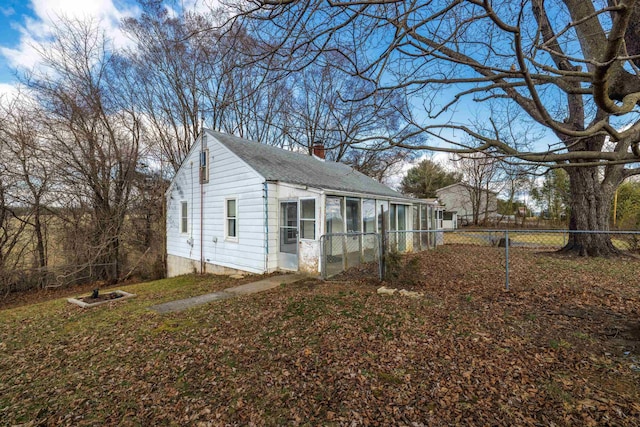 view of property exterior featuring a shingled roof, a chimney, and fence