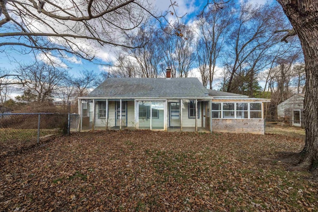 ranch-style home with fence, roof with shingles, a chimney, a sunroom, and a gate