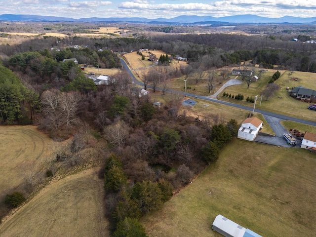 birds eye view of property featuring a mountain view, a view of trees, and a rural view