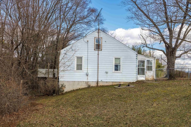 view of side of home with a lawn and fence