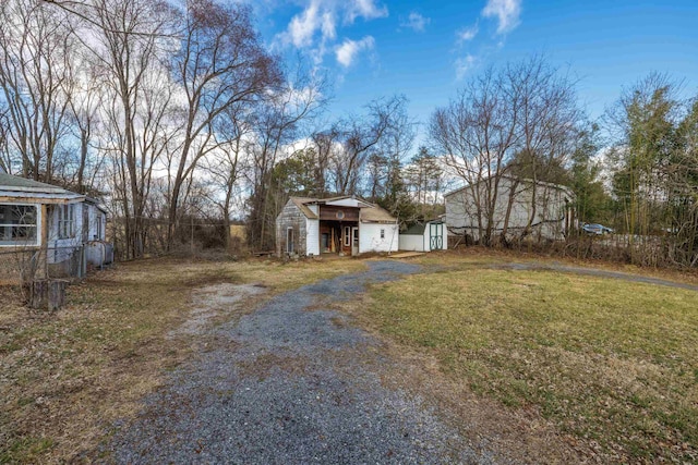 view of yard with an outbuilding and driveway