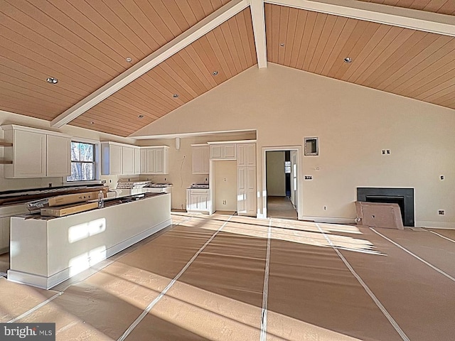 kitchen with high vaulted ceiling, wooden ceiling, beam ceiling, and white cabinets