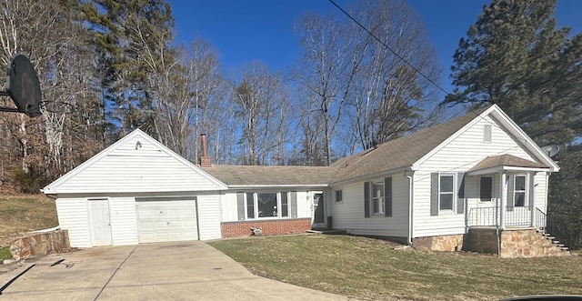 view of front of house with a garage, concrete driveway, a chimney, a front yard, and brick siding