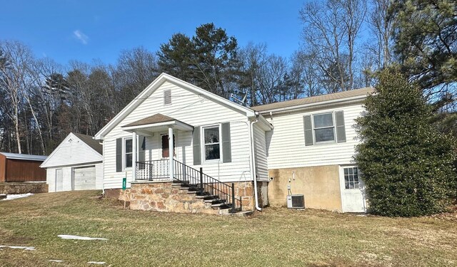 view of front of house with an outdoor structure, a garage, central AC, and a front yard