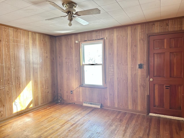 empty room with a ceiling fan, wood-type flooring, and baseboards