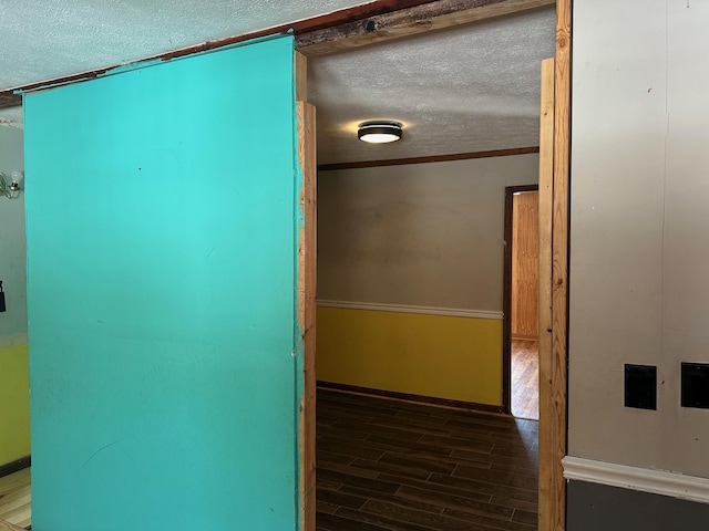 interior space featuring hardwood / wood-style flooring, ornamental molding, and a textured ceiling