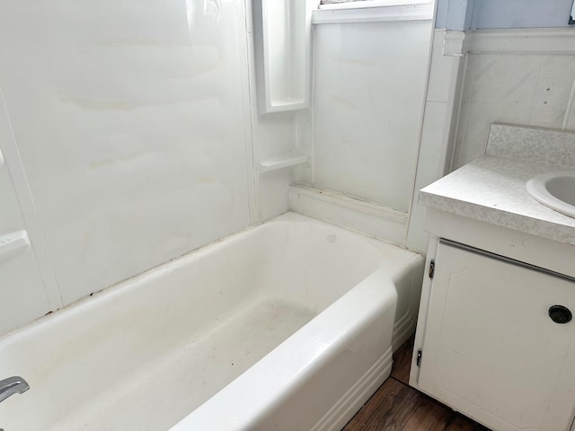 bathroom featuring a washtub, vanity, and wood-type flooring