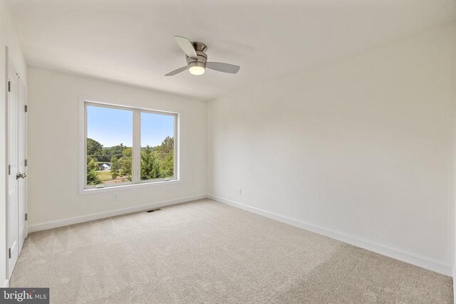 spare room featuring ceiling fan and light colored carpet