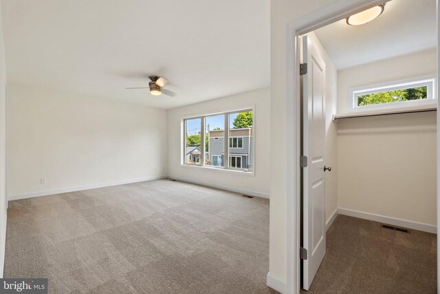 carpeted spare room featuring ceiling fan