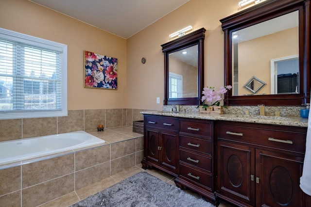 full bathroom with a garden tub, double vanity, tile patterned flooring, and a sink