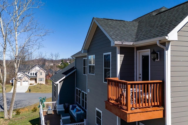 view of side of property with roof with shingles and a residential view