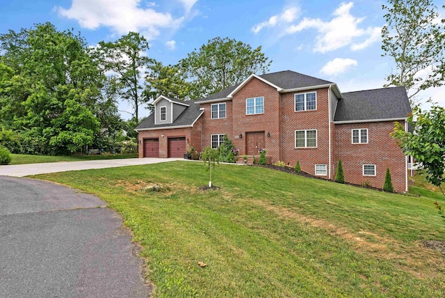 colonial house with a garage, a front lawn, concrete driveway, and brick siding