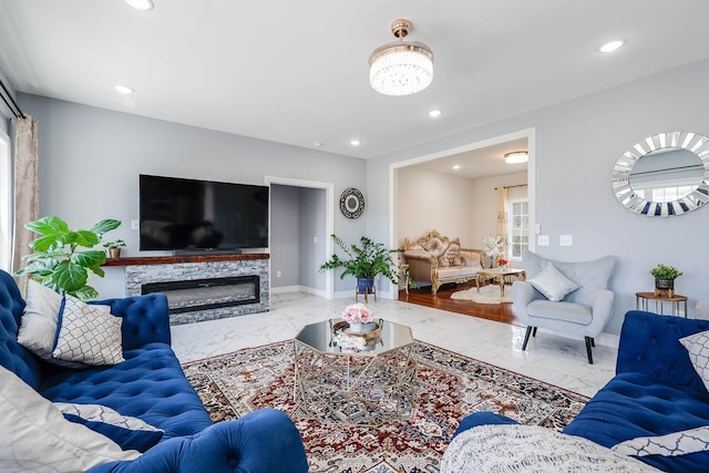 living area featuring marble finish floor, baseboards, a stone fireplace, and recessed lighting