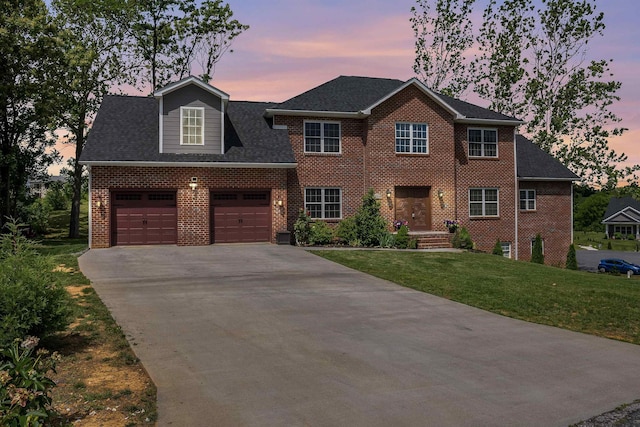 colonial-style house with a garage, concrete driveway, brick siding, and a front lawn