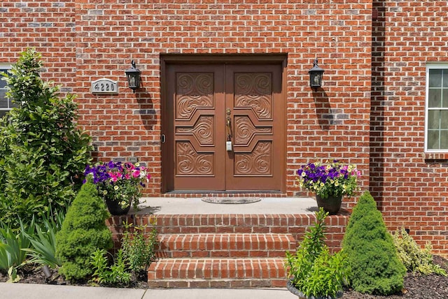 doorway to property featuring brick siding