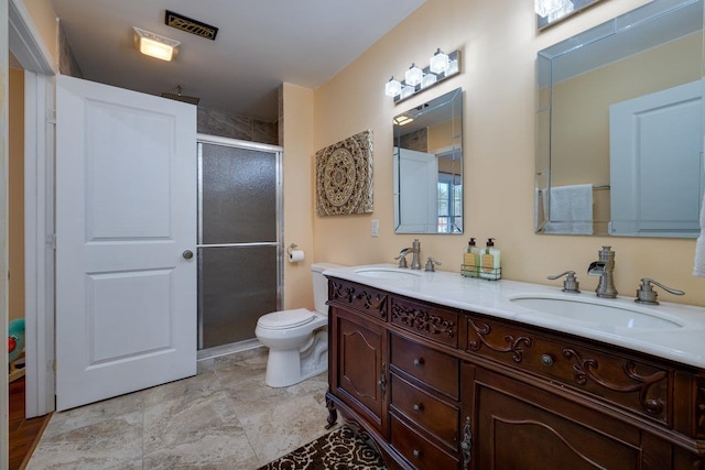 full bathroom featuring double vanity, a sink, toilet, and a shower stall