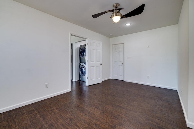 unfurnished bedroom with a ceiling fan, baseboards, dark wood-type flooring, and stacked washer / drying machine