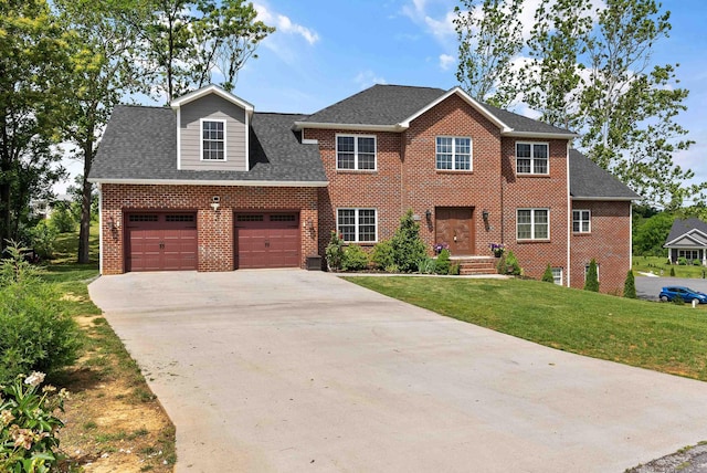 colonial home with brick siding, a shingled roof, a front yard, a garage, and driveway