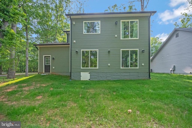 rear view of house featuring a yard