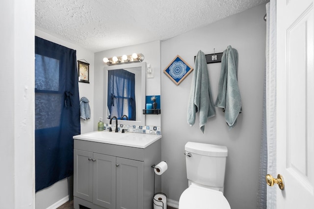 bathroom featuring vanity, toilet, and a textured ceiling